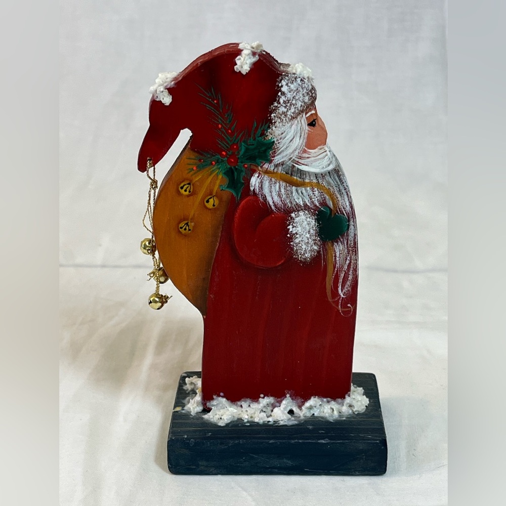 Painted wood Santa figure holding toy bag. Approx 5.5” H x 3” W. Hand painted.